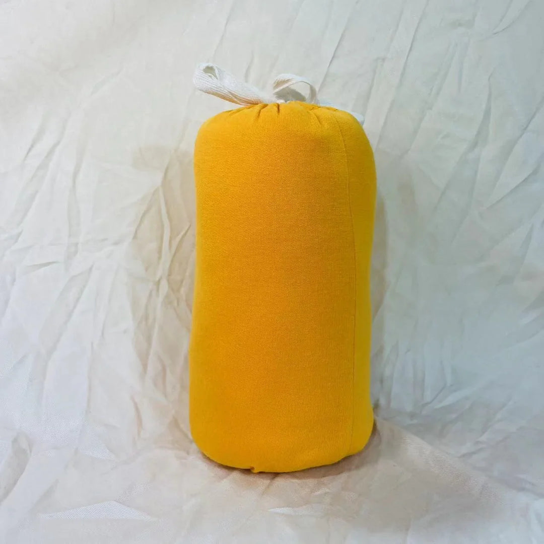Bright yellow fabric draft stopper with white tie on wrinkled white cloth background