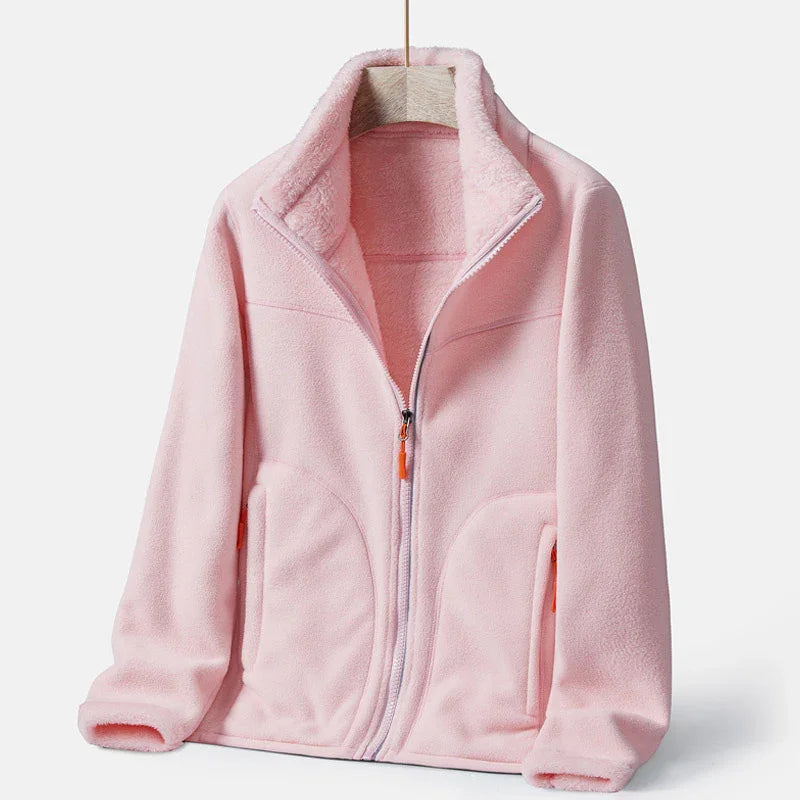 Soft pink fleece jacket with zipper and high collar, displayed on hanger against white background