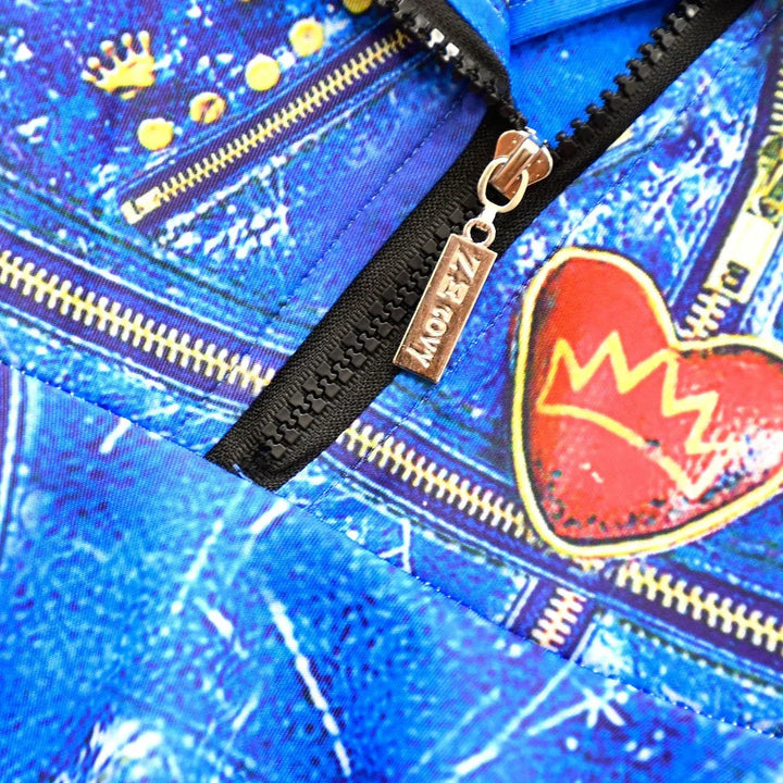 Close-up of blue denim fabric with gold zippers, red heart patch, and metal zipper pull with ZAZOWY logo