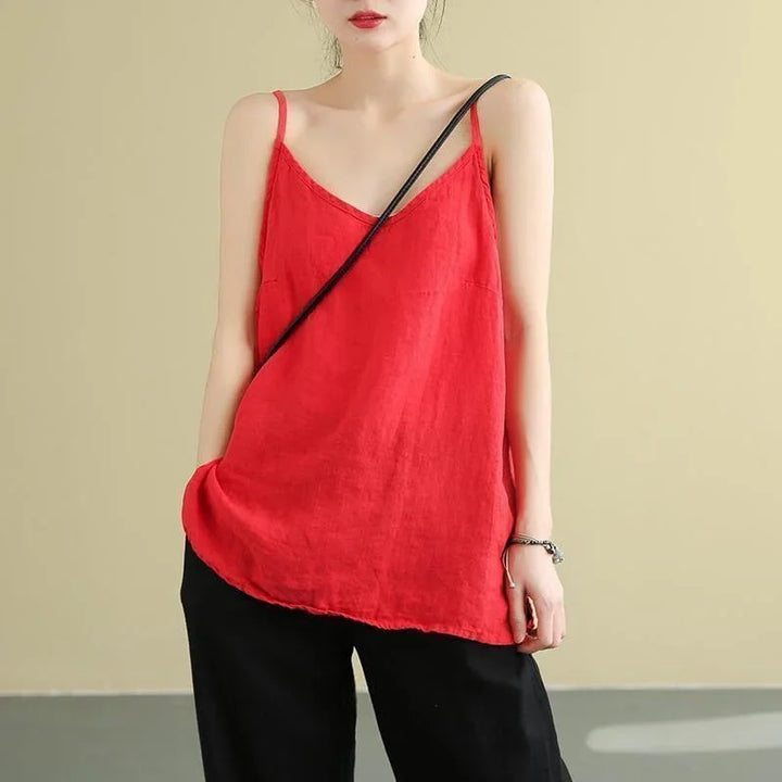 Woman wearing red linen spaghetti strap top with black pants and a black crossbody bag
