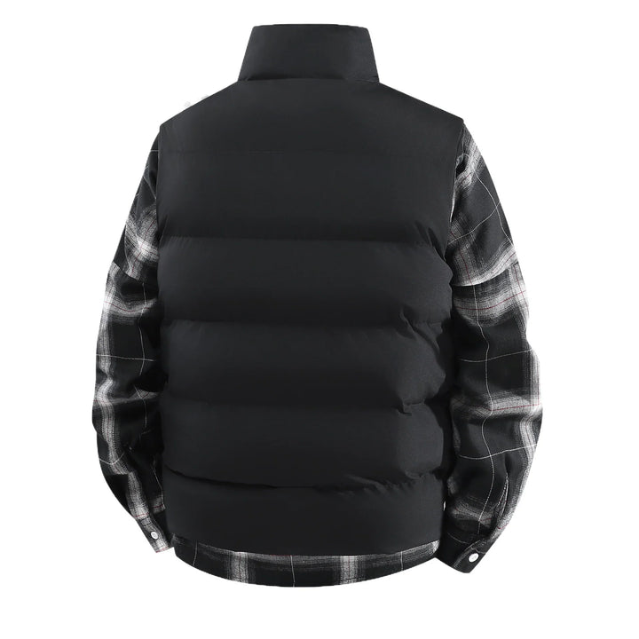 Back view of black puffer vest layered over black and white plaid shirt with buttoned cuffs