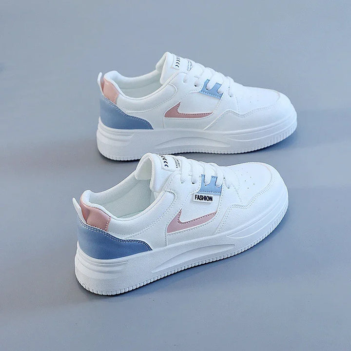 Pair of white sneakers with pink and blue accents and FASHION label on light gray background