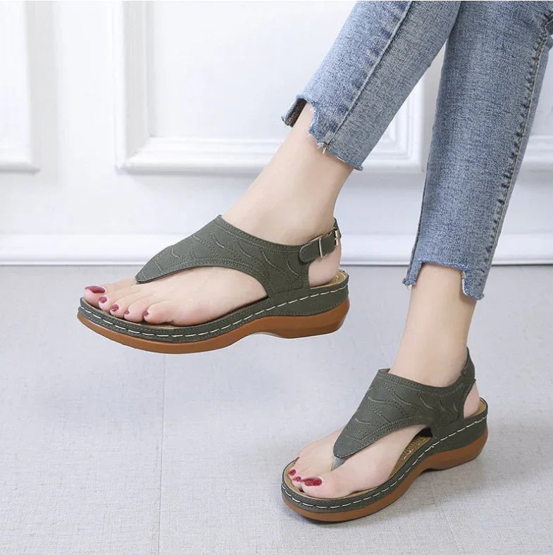 Women wearing olive green platform sandals with brown soles and ankle straps, paired with distressed blue jeans