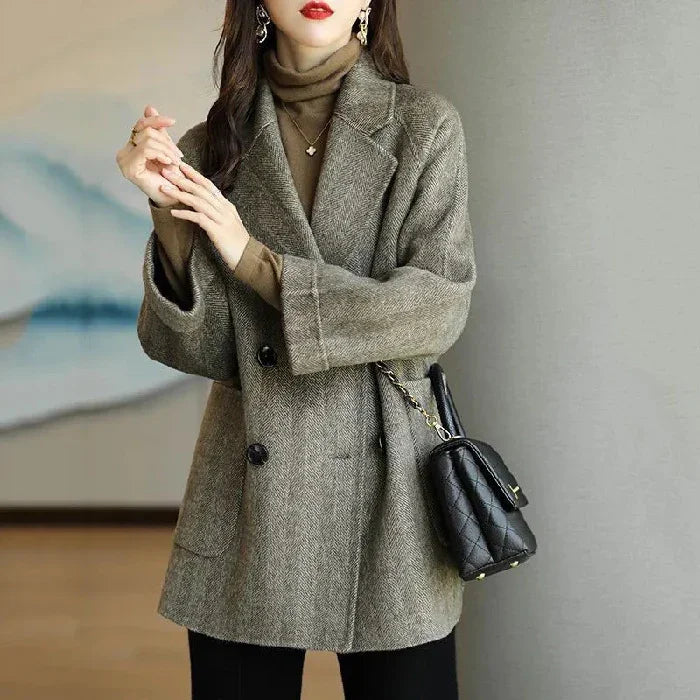Woman wearing brown wool blazer and turtleneck sweater with black quilted handbag