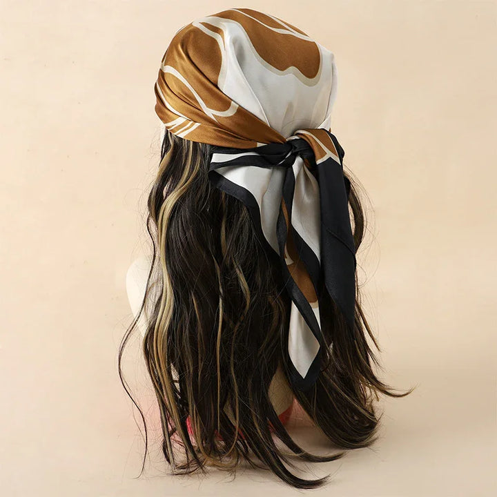 Long wavy black hair with blonde highlights styled with a brown, white, and black patterned headscarf tied at the back