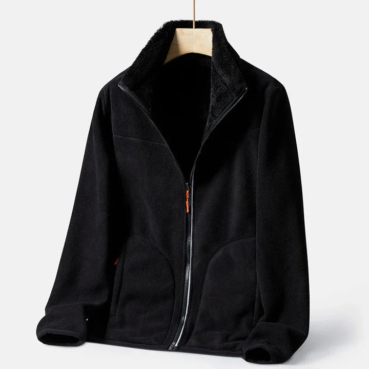 Black fleece zip-up jacket with high collar and cozy soft texture hanging on wooden hanger