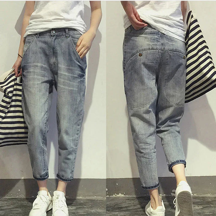 Front and back view of casual light blue denim jeans worn with white sneakers and carrying a striped tote bag