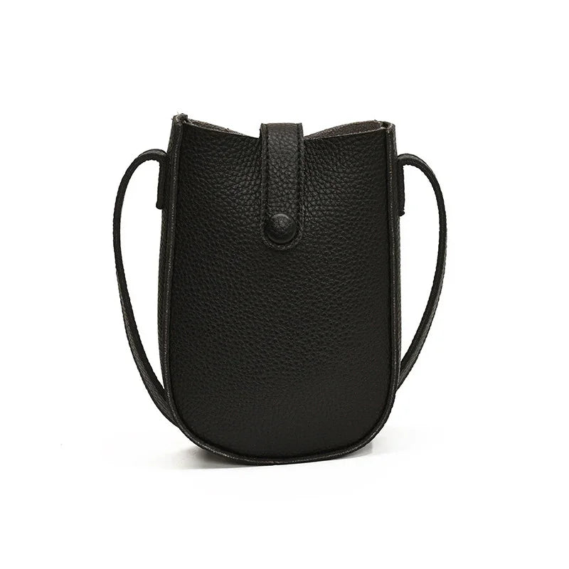 Black textured leather crossbody bag with snap closure and slim shoulder strap