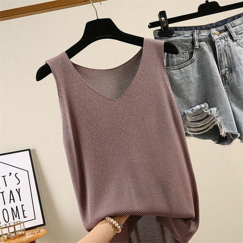 Mauve knitted sleeveless V-neck top hanging on black hanger beside light blue distressed denim shorts