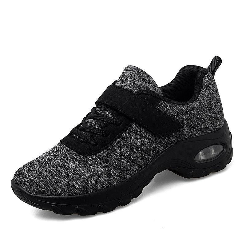 Black and gray athletic sneaker with quilted fabric, lace and strap closure, and cushioned sole