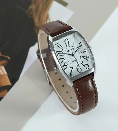 Kapwi wristwatch with white dial, distorted black numerals, silver case, and brown leather strap