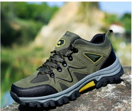 green and black hiking shoe with rugged sole on outdoor rock surface