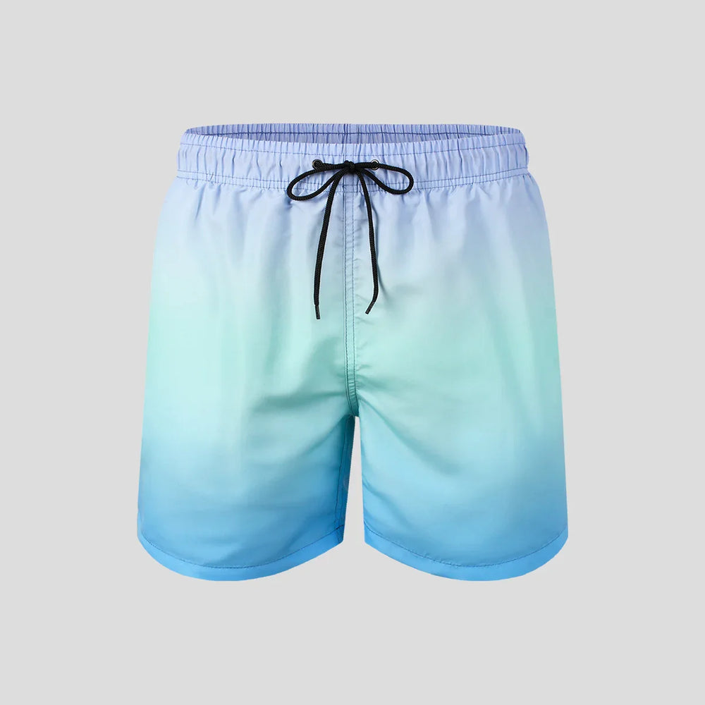 Men's light blue to teal ombre swim shorts with black drawstring on gray background