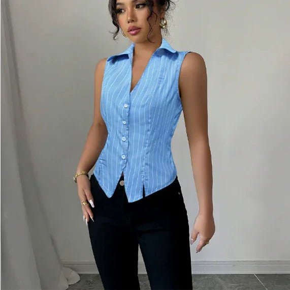woman wearing sleeveless blue pinstripe button-up shirt with collar and black pants in minimalist indoor setting