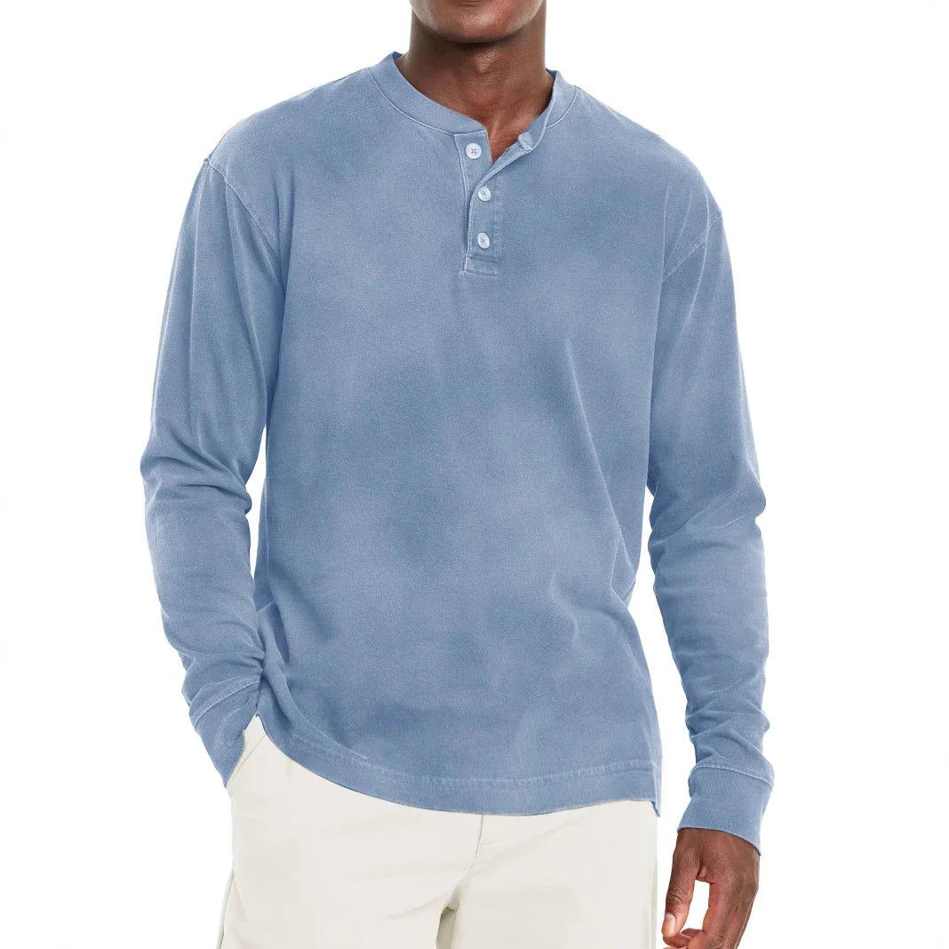 Man wearing light blue long-sleeve henley shirt with buttons and beige pants