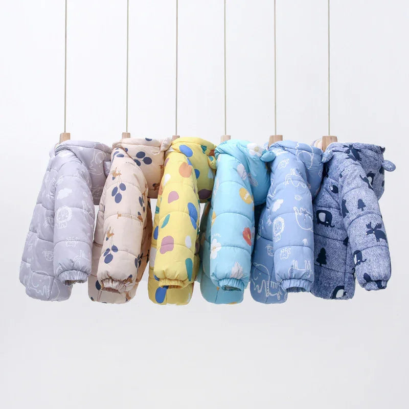 Colorful children's puffer jackets with animal and nature prints hanging on wooden hangers