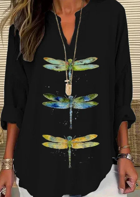 Woman wearing black V-neck long sleeve top with colorful dragonfly prints and layered necklace