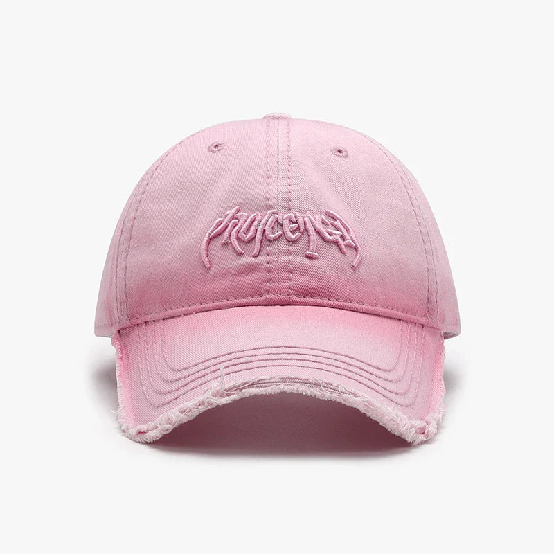 Pink distressed baseball cap with embroidered text front and curved brim