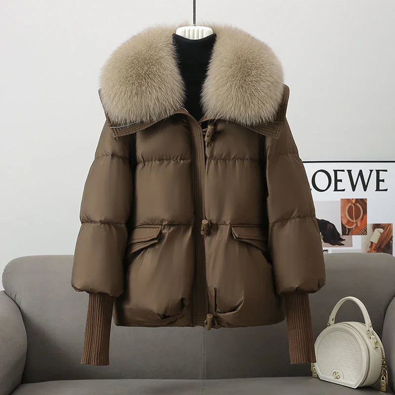 Brown puffer jacket with oversized fur collar and ribbed cuffs on mannequin in modern living room