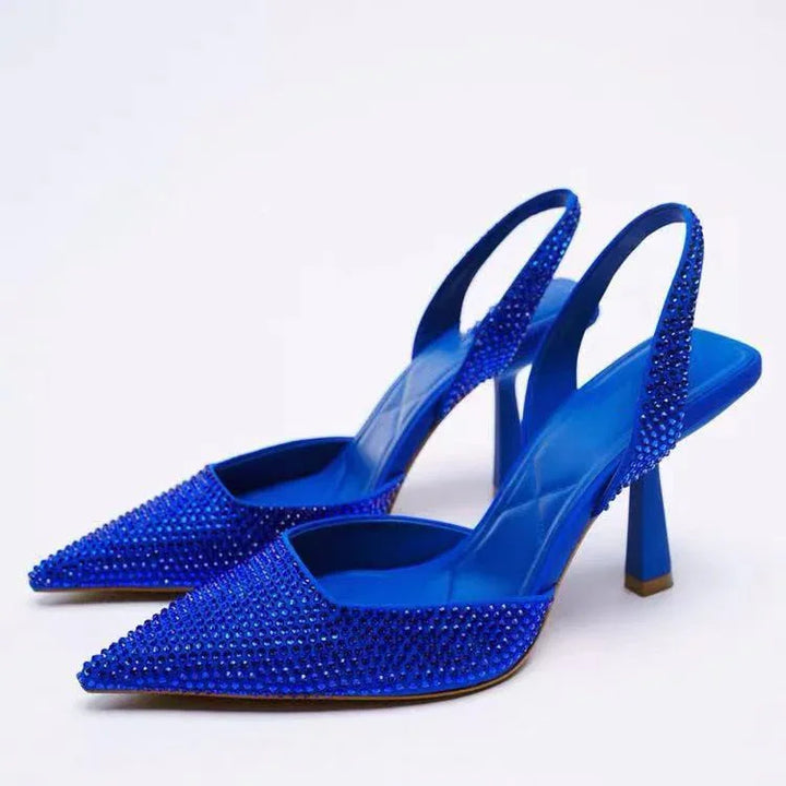 Pair of blue high-heeled slingback shoes with pointed toes and sparkling rhinestone embellishments