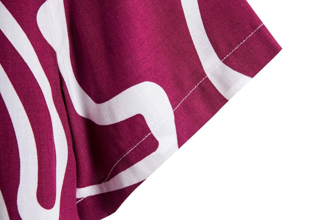 Close-up of maroon fabric with white abstract pattern and detailed stitching