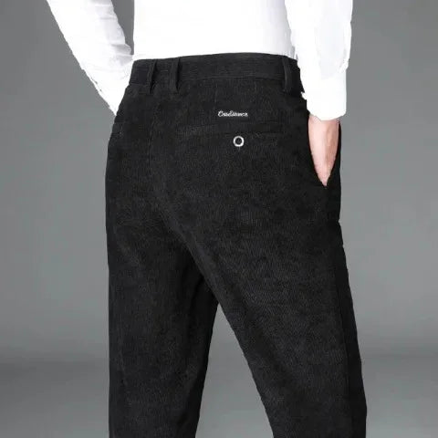 Rear view of person wearing black Corduroy pants with 'Cordiano' embroidered logo on pocket
