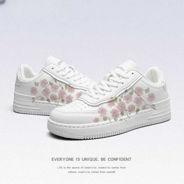 White sneakers with pink rose floral pattern and green leaves, stylish casual shoes on white background