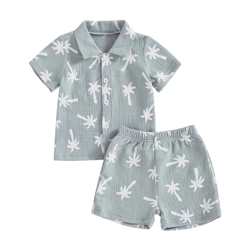 Light blue toddler summer outfit with white palm tree print, short sleeve button shirt and elastic waist shorts