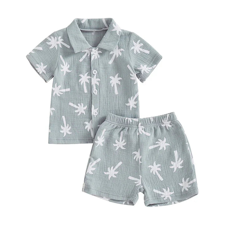 Light blue toddler summer outfit with white palm tree print, short sleeve button shirt and elastic waist shorts