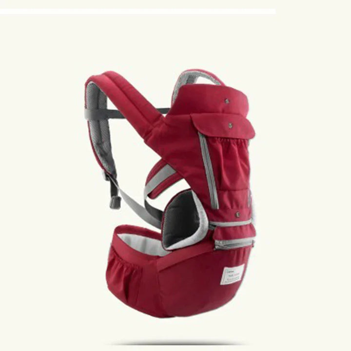 Red ergonomic baby carrier with padded shoulder straps and waist support for comfortable front carrying