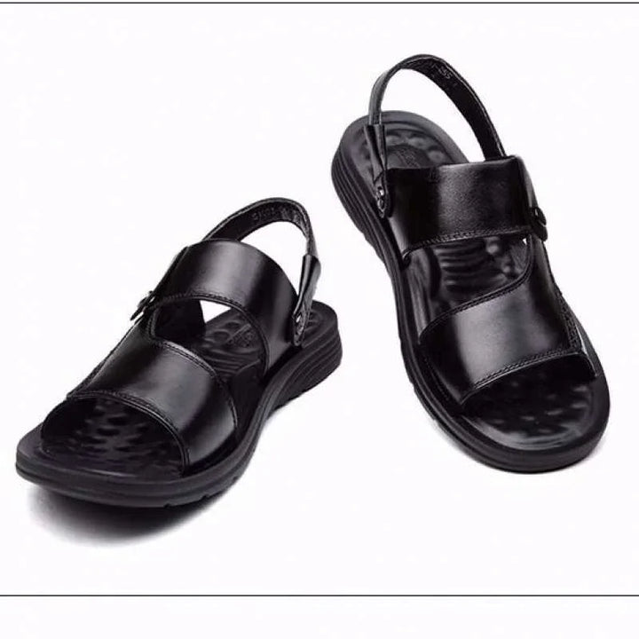 Pair of black leather open-toe men's sandals with adjustable ankle straps and textured footbeds