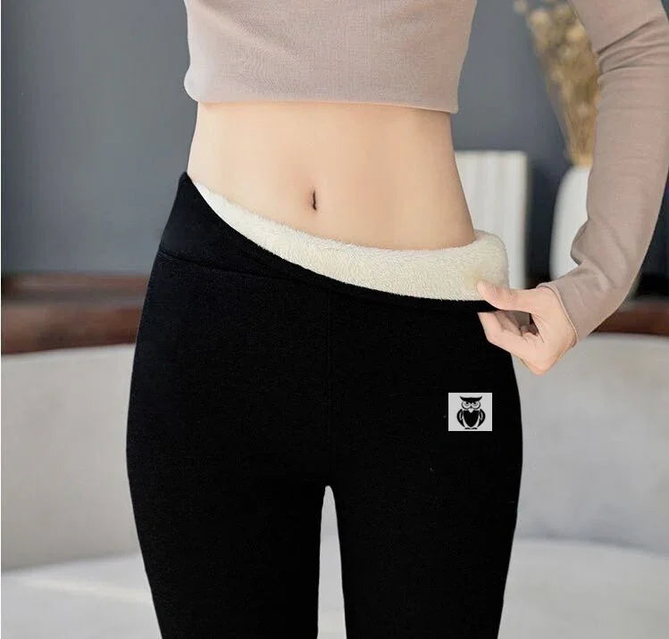 Close-up of woman wearing black fleece-lined leggings with beige crop top indoors