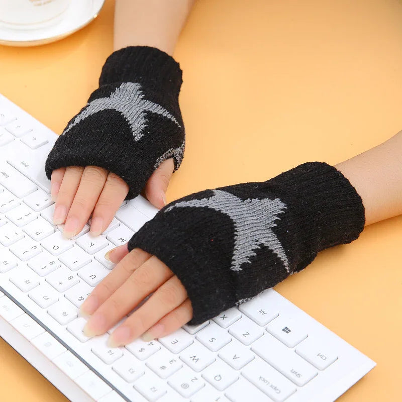 Hands wearing black fingerless gloves with gray star design typing on white keyboard