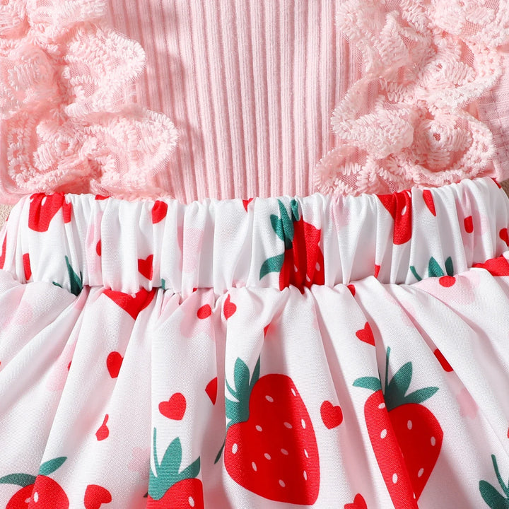 Pink ribbed fabric top with ruffled lace sleeves and white skirt with red strawberry print
