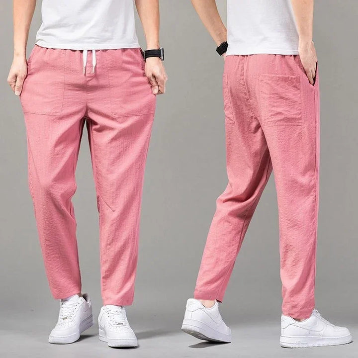 Front and back view of person wearing casual pink drawstring pants and white sneakers