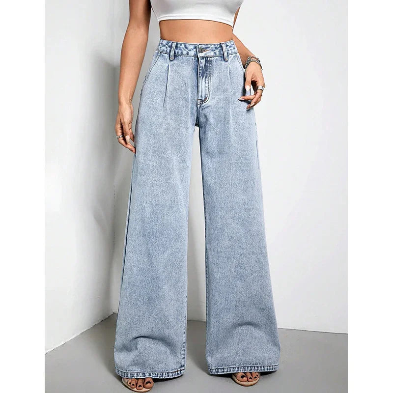 Woman wearing high-waisted light blue wide-leg jeans with pleats and white crop top