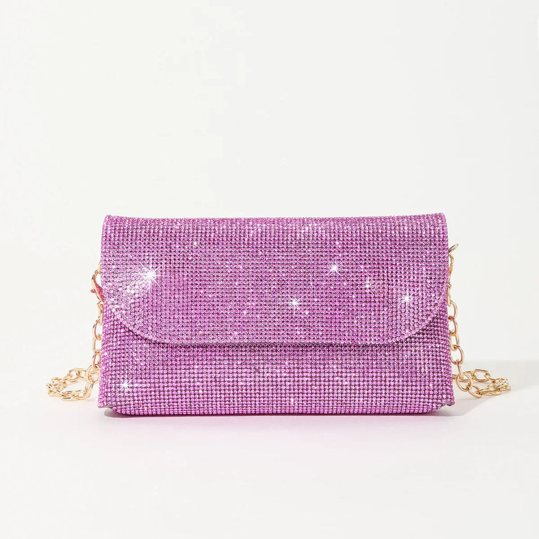 Sparkling pink rhinestone clutch purse with gold chain strap on white background