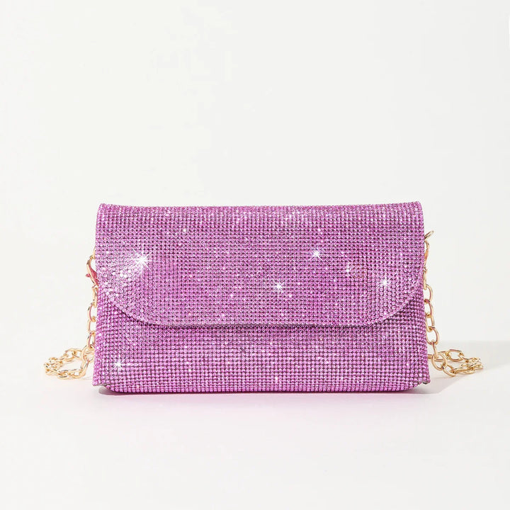 Sparkling pink rhinestone clutch purse with gold chain strap on white background