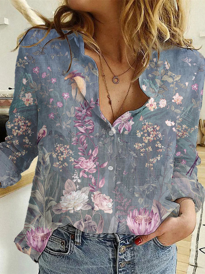 Woman wearing blue floral button-up blouse with pink and white flowers and leaves, paired with blue jeans