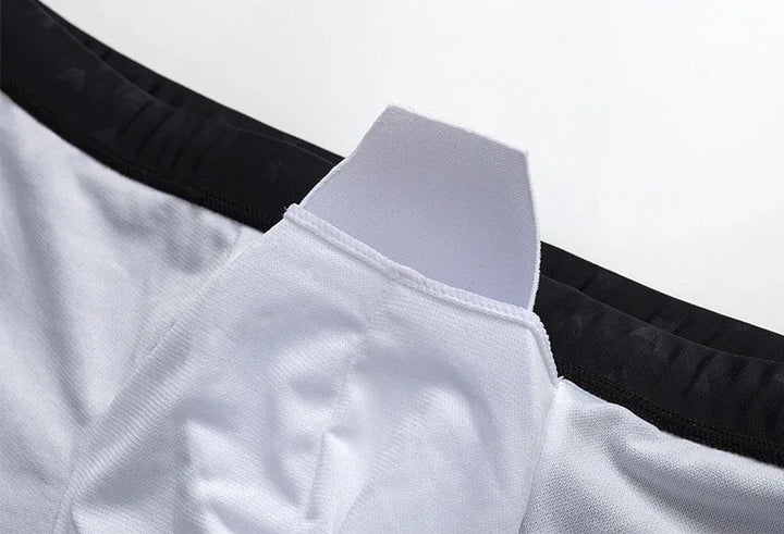 Close-up of white athletic shorts with black waistband and padded crotch support