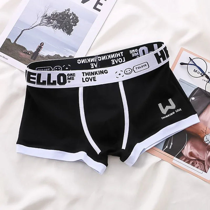 Black men's boxer briefs with white trim and waistband featuring text and smiley face design