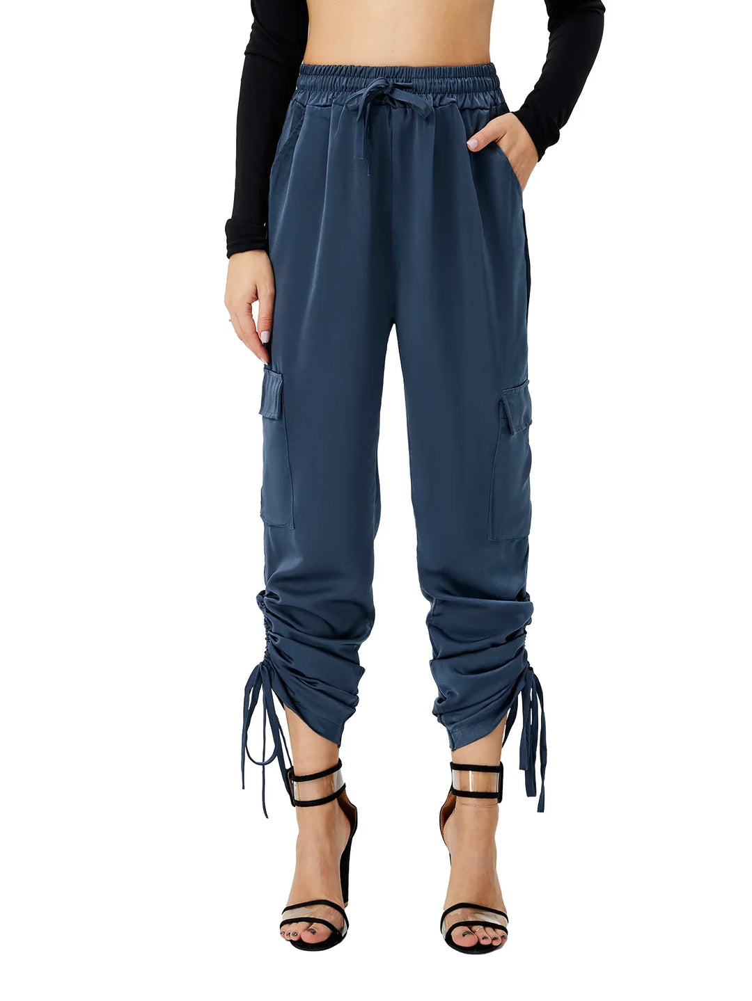 Woman wearing navy blue satin cargo pants with ruched drawstring cuffs and black high heel sandals
