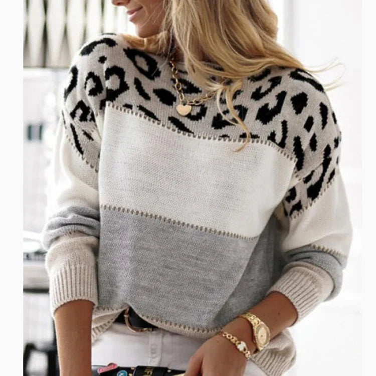 Woman wearing a cozy color-block sweater with leopard print top and grey and white sections, accessorized with gold jewelry