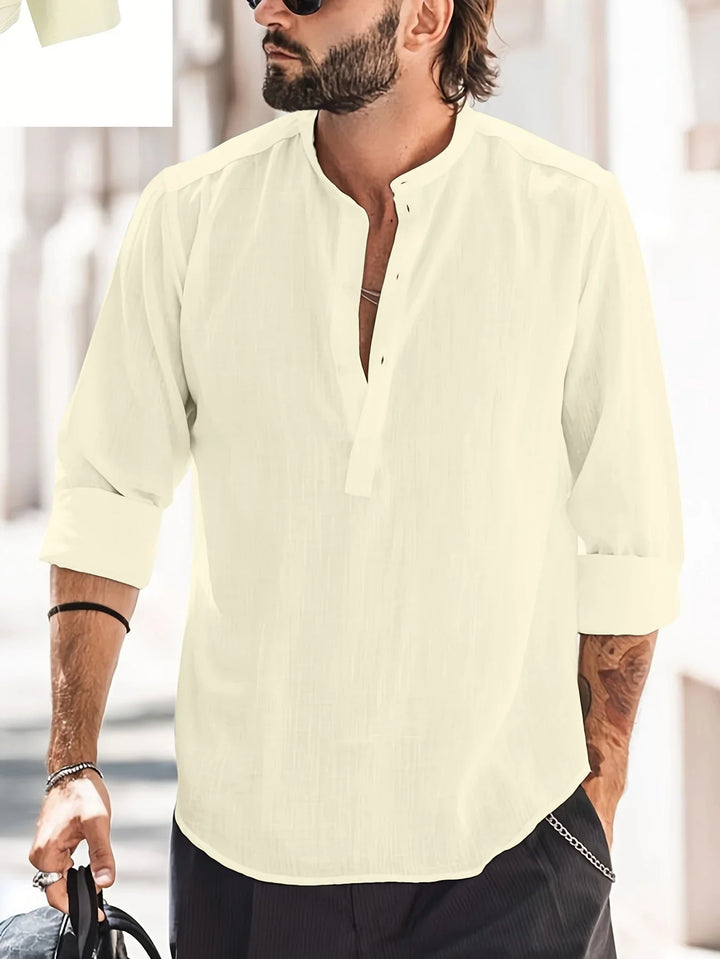 bearded man wearing cream casual long-sleeve linen shirt with rolled cuffs and sunglasses