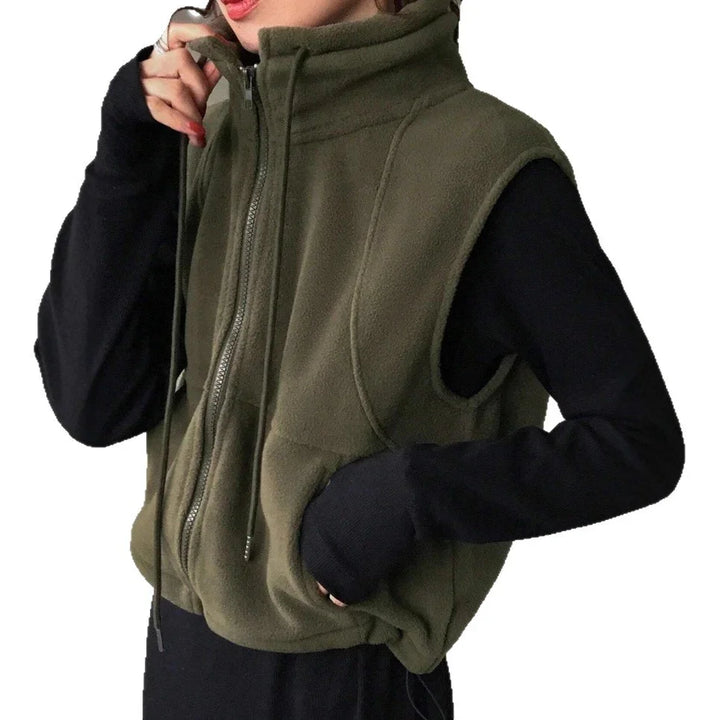 person wearing olive green fleece sleeveless zip-up vest over black long-sleeve top
