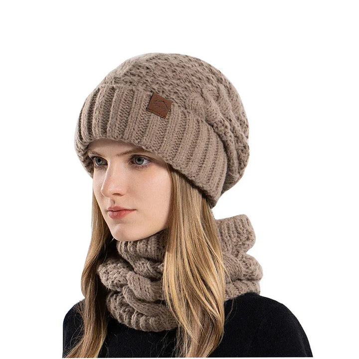 Woman wearing beige knitted beret and matching chunky cable knit neck warmer on white background