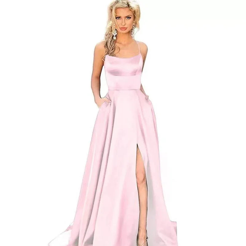 Blonde woman wearing a light pink satin evening gown with spaghetti straps and thigh-high slit