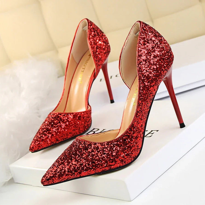 Red glitter high heel stilettos with pointed toes displayed on white boxes