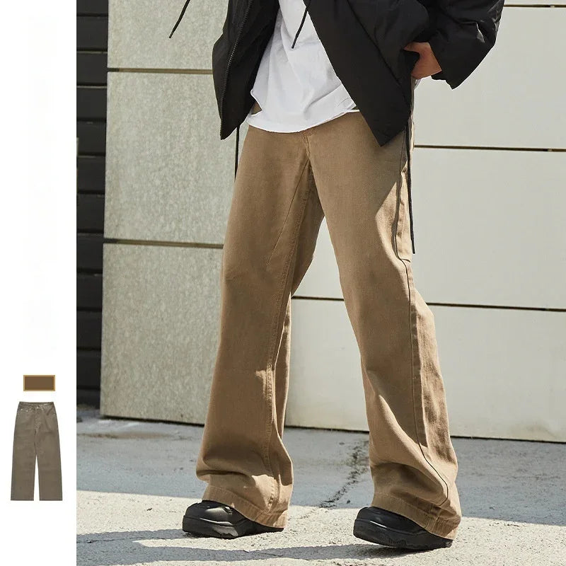 Person wearing beige wide-leg pants with black shoes and a black jacket standing outdoors