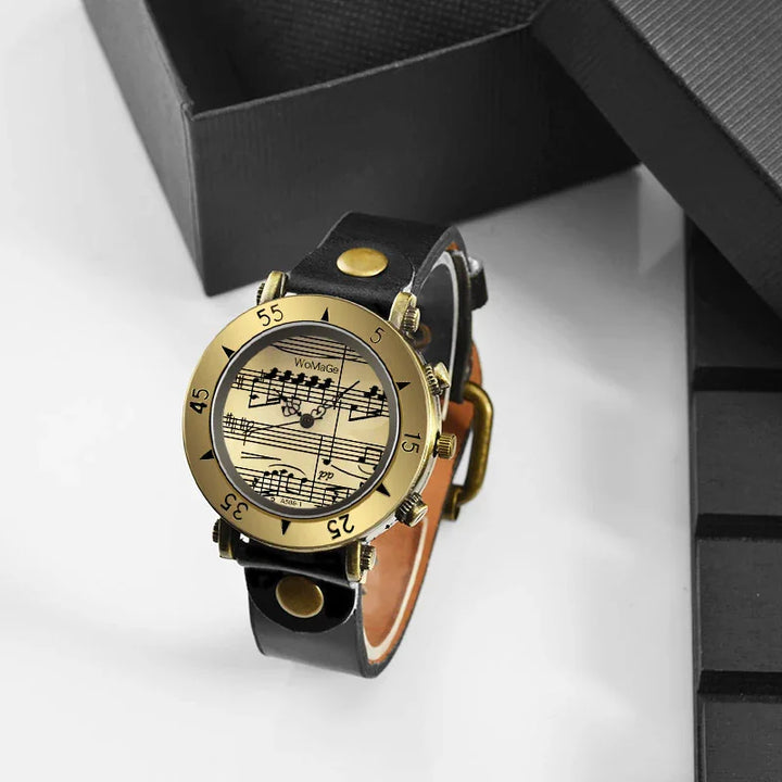 Vintage wristwatch with black leather strap and gold-tone bezel featuring musical notes design on dial